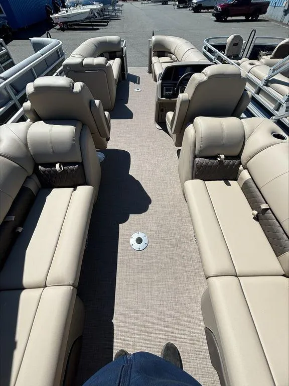 Slide: The Image of 2022 Sun Tracker PB 24 DLX pontoon boat with beige seating and spacious deck. - 4