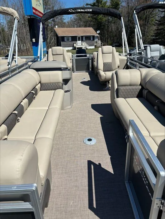 Slide: The Image of 2022 Sun Tracker PB 24 DLX pontoon boat with beige seating and spacious deck. - 5