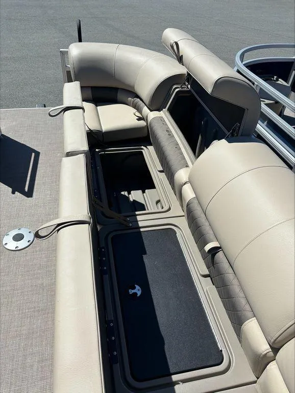 Slide: The Image of 2022 Sun Tracker PB 24 DLX pontoon boat with beige seating and storage compartments. - 6
