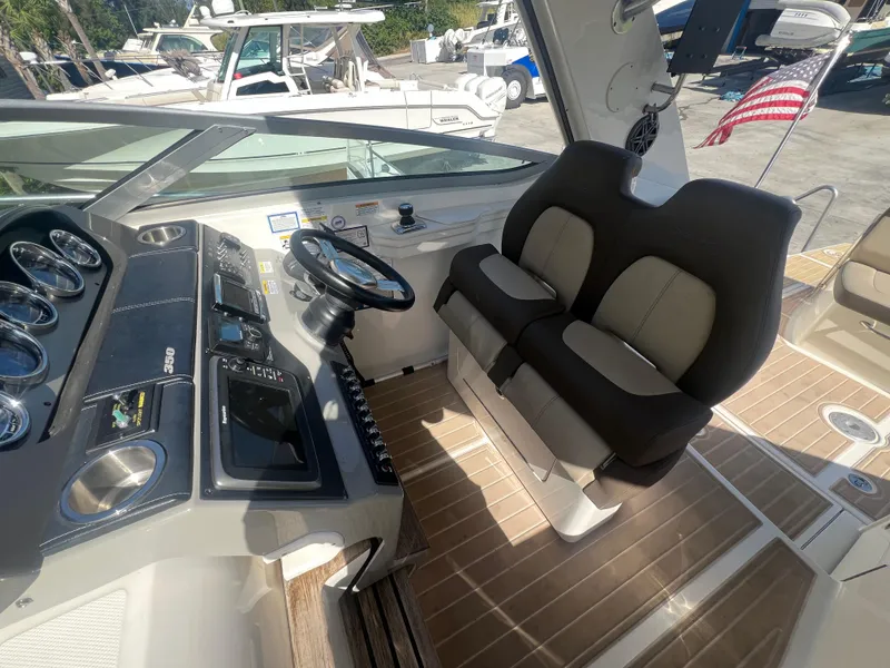 Slide: The Image of 2014 Sea Ray 350 Sundancer cockpit with dual seating and modern dashboard. - 10