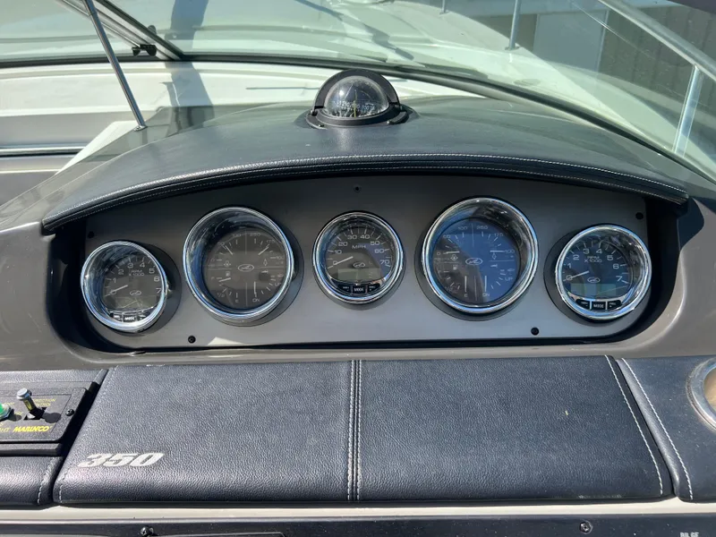 Slide: The Image of Dashboard of a 2014 Sea Ray 350 Sundancer boat with gauges and controls. - 13