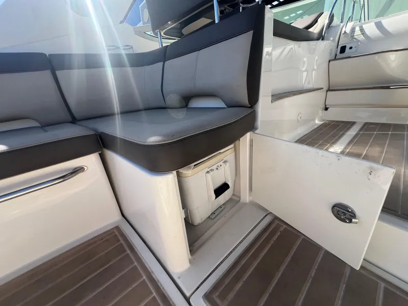Slide: The Image of 2014 Sea Ray 350 Sundancer interior seating with storage compartment open. - 21