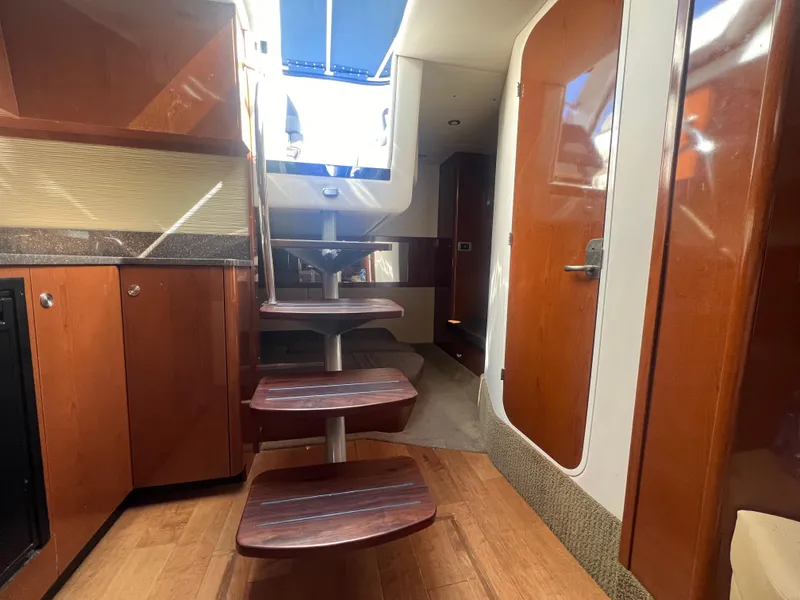 Slide: The Image of Interior of 2014 Sea Ray 350 Sundancer with wooden stairs and cabinetry. - 29