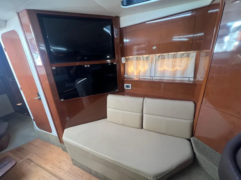 Slide: The Image of Interior of 2014 Sea Ray 350 Sundancer with beige sofa and mounted TV. - 31