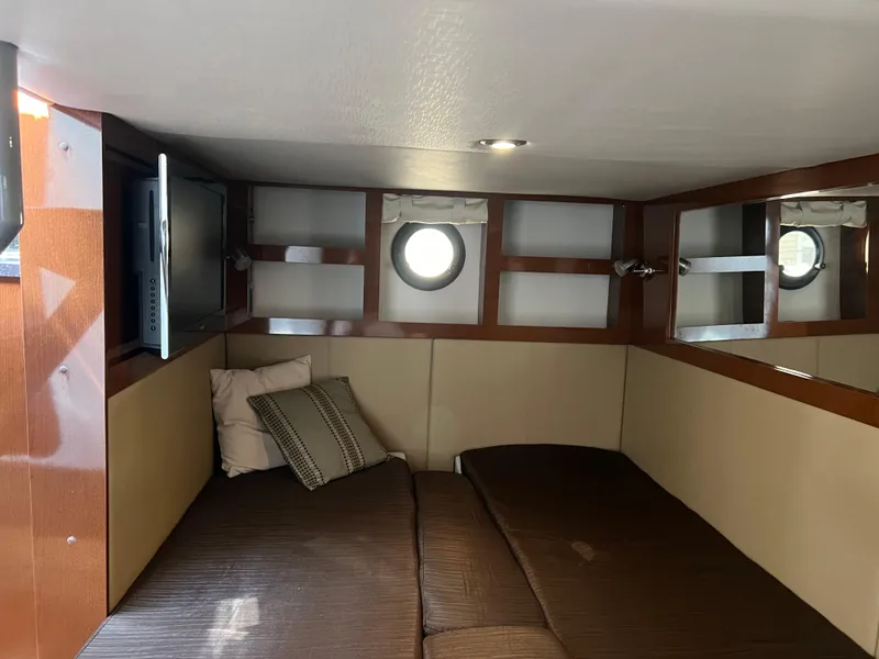 Slide: The Image of 2014 Sea Ray 350 Sundancer cabin interior with bed, pillows, and TV. - 37