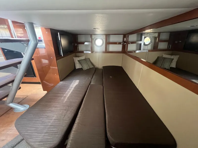 Slide: The Image of 2014 Sea Ray 350 Sundancer cabin interior with brown seating and porthole windows. - 38