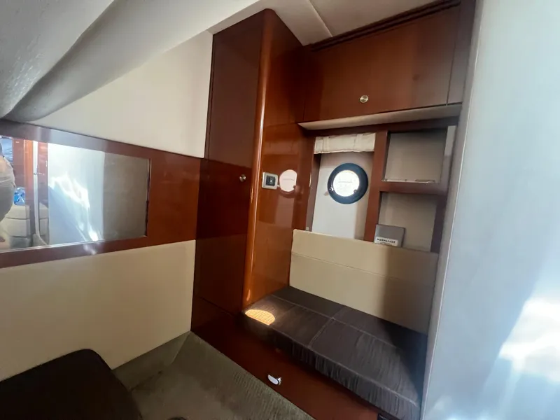 Slide: The Image of Interior cabin of 2014 Sea Ray 350 Sundancer yacht with wooden cabinetry and porthole. - 39