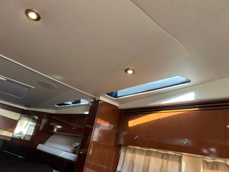 Slide: The Image of Interior of 2014 Sea Ray 350 Sundancer with skylights and wooden cabinetry. - 41