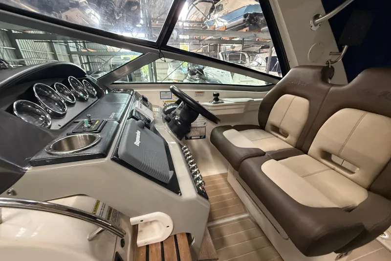Slide: The Image of 2014 Sea Ray Sundancer 350 cockpit with dual seats and modern dashboard controls. - 48