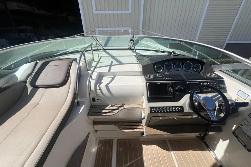 Slide: The Image of 2014 Sea Ray 350 Sundancer boat cockpit with steering wheel and control panel. - 9