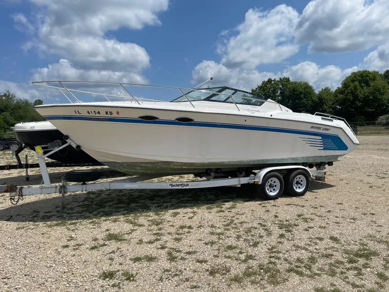 The Image of 1995 Sport-Craft 2500 AVANZA boat on a trailer under a partly cloudy sky. - 2
