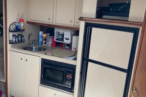 Slide: The Image of Compact kitchen in a 2000 Cruisers 3870 yacht with sink, microwave, and fridge. - 4