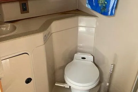 Slide: The Image of Bathroom interior of 2000 Cruisers 3870 yacht, featuring a compact toilet and sink. - 5