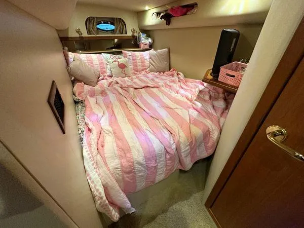 Slide: The Image of Cozy bedroom in 2000 Cruisers 3870 yacht with pink striped bedding. - 7