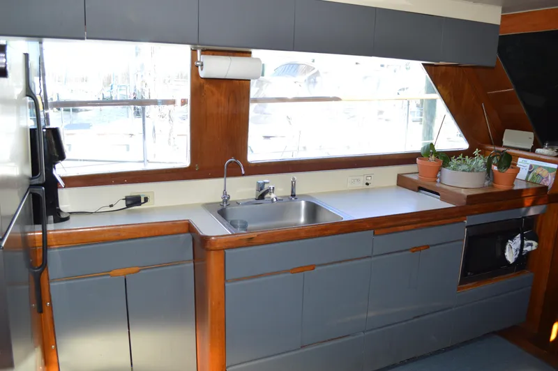 Slide: The Image of 1986 Gulfstar 49 Motor Yacht kitchen with sink, cabinets, and large windows. - 14