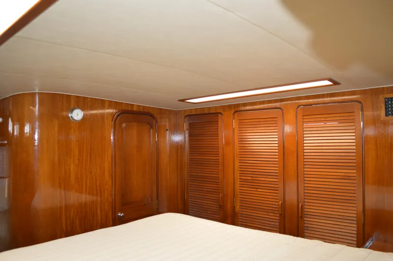Slide: The Image of 1986 Gulfstar 49 Motor Yacht cabin with wooden paneling and louvered closet doors. - 20