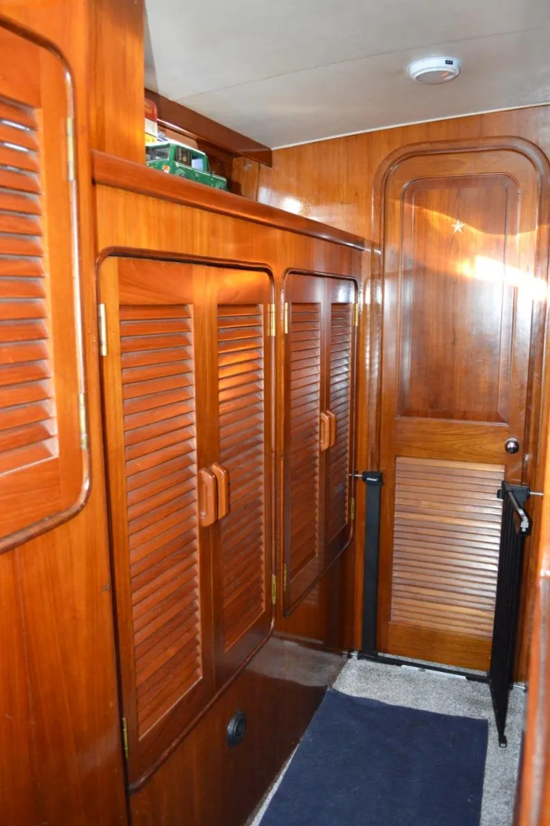 Slide: The Image of Interior hallway of a 1986 Gulfstar 49 Motor Yacht with wooden cabinetry. - 23