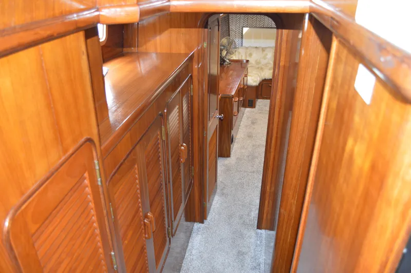 Slide: The Image of Interior hallway of 1986 Gulfstar 49 Motor Yacht with wooden cabinetry and carpeted floor. - 24