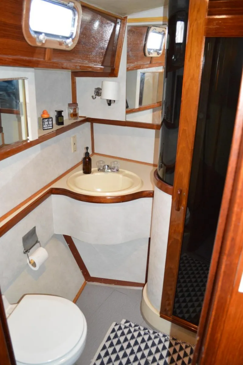 Slide: The Image of Bathroom interior of 1986 Gulfstar 49 Motor Yacht with sink, toilet, and wooden accents. - 25