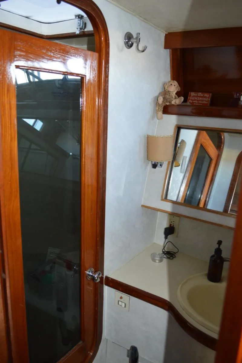 Slide: The Image of 1986 Gulfstar 49 Motor Yacht bathroom with wooden door, sink, and mirror. - 27