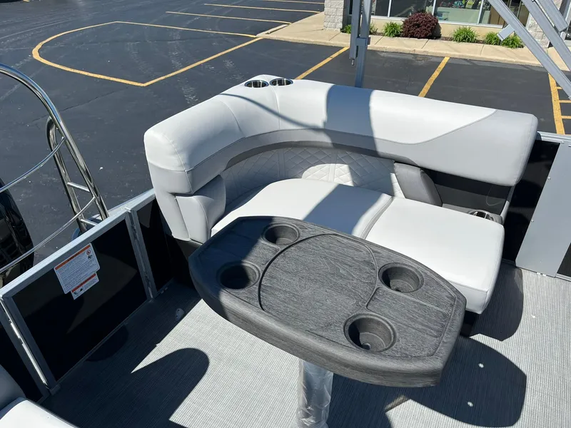 Slide: The Image of 2024 Lowe SS 210 WT pontoon boat with cushioned seating and cup holder table. - 16