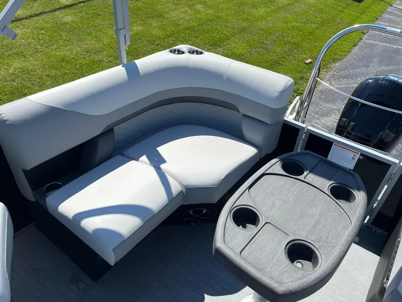 Slide: The Image of 2024 Lowe SS 210 WT boat interior with cushioned seating and cupholder table. - 17