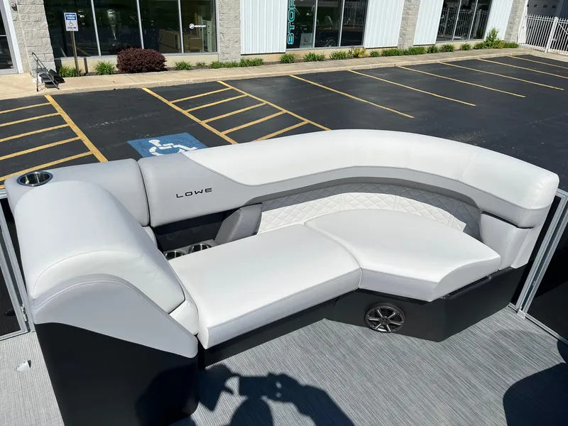 Slide: The Image of 2024 Lowe SS 210 WT boat with white and gray seating in a parking lot. - 19