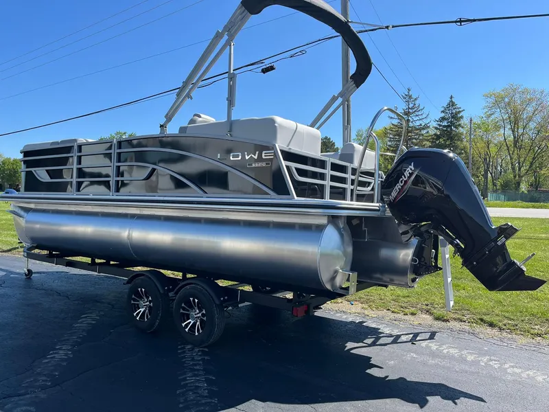 Slide: The Image of 2024 Lowe SS 210 WT pontoon boat with Mercury outboard motor on trailer. - 2