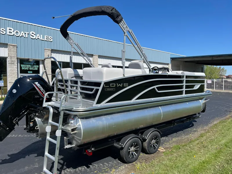 Slide: The Image of 2024 Lowe SS 210 WT pontoon boat on trailer outside dealership. - 5