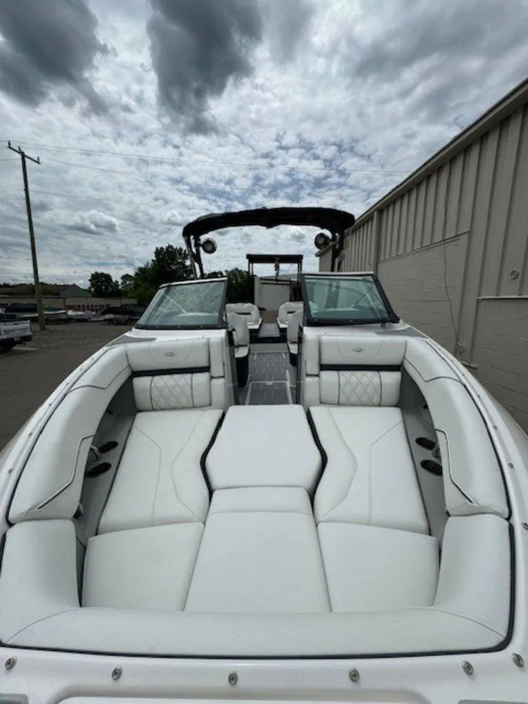 Slide: The Image of 2024 Regal LS4 Surf boat with luxurious white seating under cloudy sky. - 6