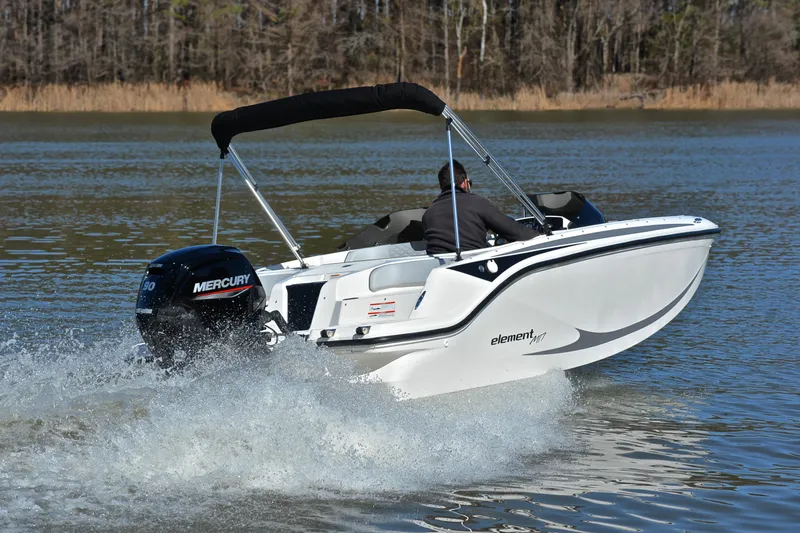 Slide: The Image of 2023 Bayliner Element M17 boat cruising on a lake with a Mercury outboard motor. - 5