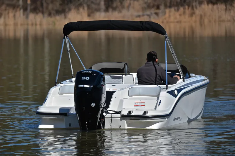 Slide: The Image of 2023 Bayliner Element M17 boat on calm water with a 90 HP outboard motor. - 8