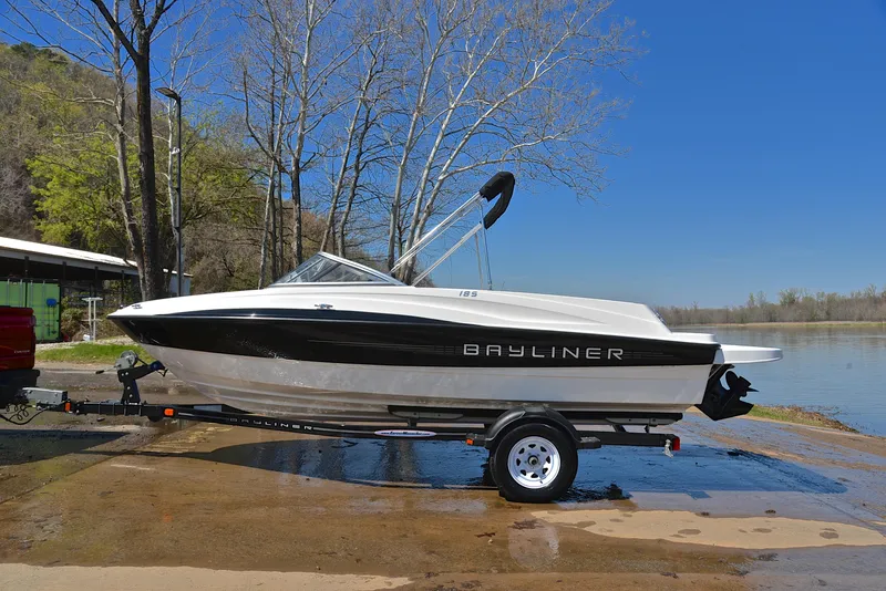 Slide: The Image of 2013 Bayliner 185 boat on trailer by a lake. - 11