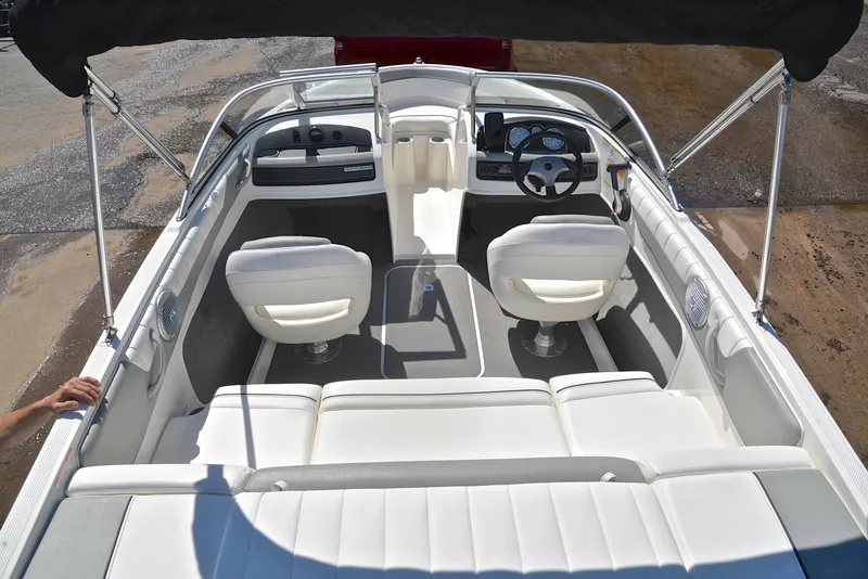 Slide: The Image of 2013 Bayliner 185 boat interior with white seating and steering console. - 18