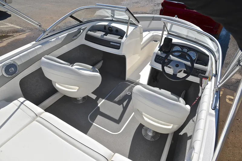 Slide: The Image of 2013 Bayliner 185 boat interior with white seats and steering console. - 19