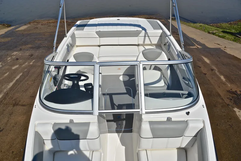 Slide: The Image of 2013 Bayliner 185 boat interior with white seating and steering wheel. - 20