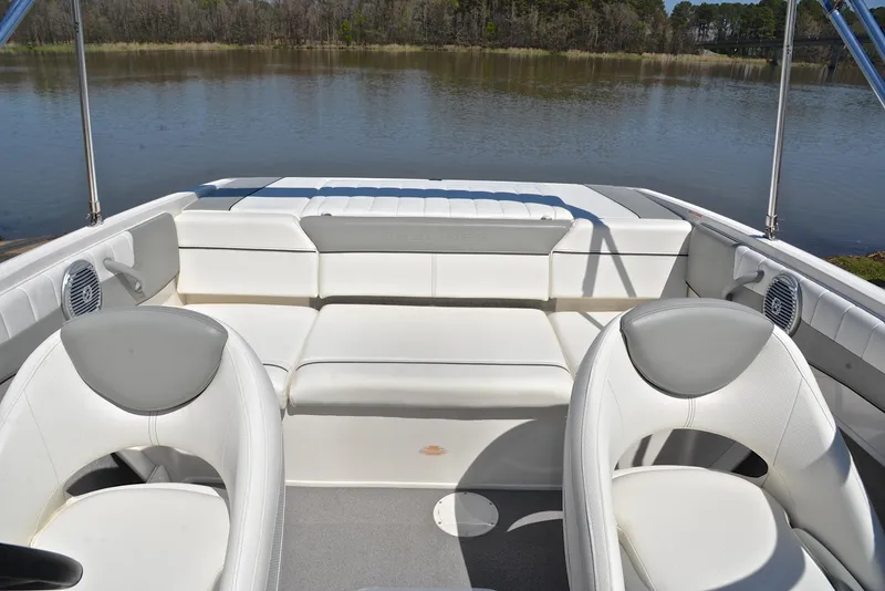 Slide: The Image of 2013 Bayliner 185 boat interior with white seating, on a calm lake. - 22