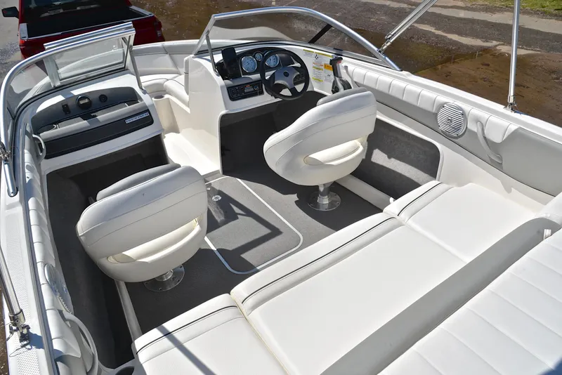 Slide: The Image of 2013 Bayliner 185 boat interior with white seating and dashboard. - 23