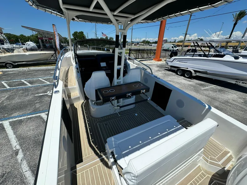 Slide: The Image of 2024 Windy SR28 CC boat interior with seating and table in a marina. - 7