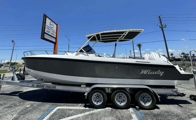 Slide: The Image of 2024 Windy SR28 CC boat on a triple-axle trailer in a parking lot. - 3