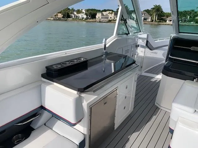 Slide: The Image of 2021 Formula 380 Super Sport Crossover OB interior with sleek kitchenette and waterfront view. - 5