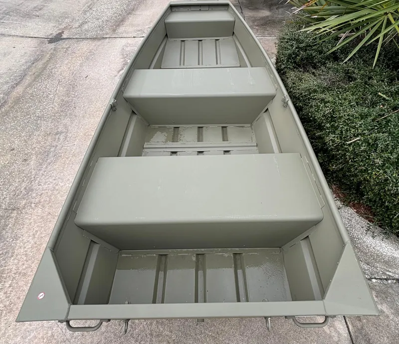 Slide: The Image of 2024 Tracker Grizzly 1236 Jon boat, top view, green color, parked on concrete. - 2