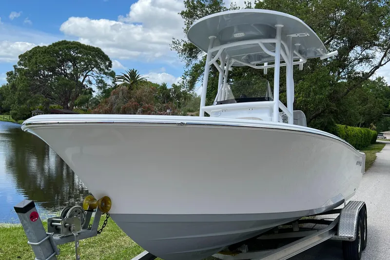 Slide: The Image of 2023 Sportsman Open 212 Platinum boat on trailer by a lake. - 10