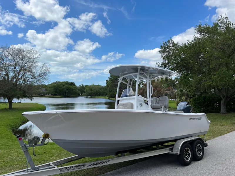 Slide: The Image of 2023 Sportsman Open 212 Platinum boat on trailer by a scenic lake. - 4