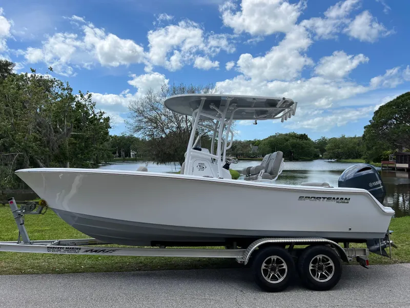 Slide: The Image of 2023 Sportsman Open 212 Platinum boat on trailer by a lake. - 5