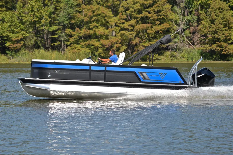 Slide: The Image of 2023 Viaggio D23S Platinum pontoon boat cruising on a lake. - 2