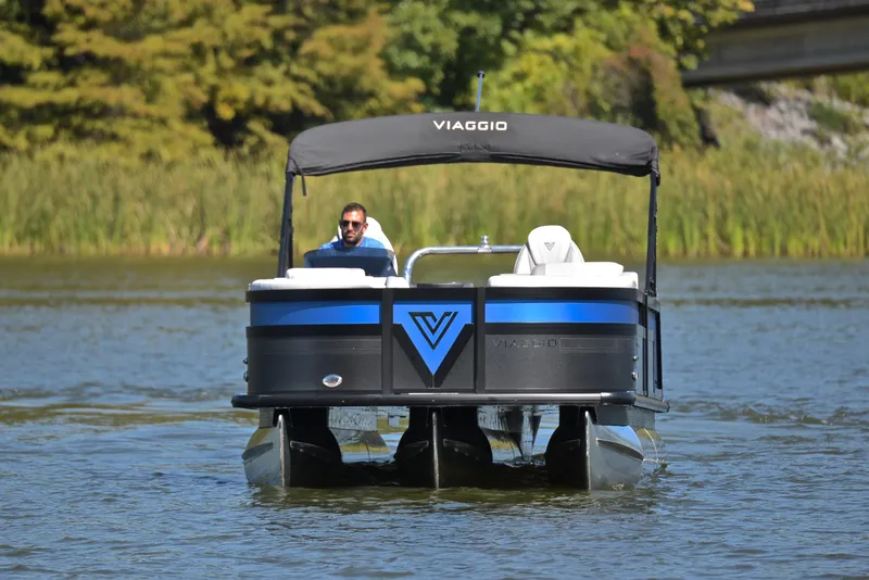 Slide: The Image of 2023 Viaggio D23S Platinum pontoon boat cruising on a lake. - 9
