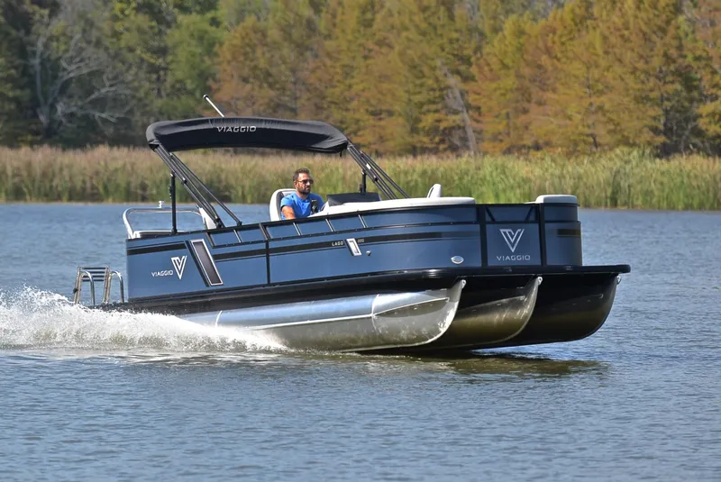 Slide: The Image of 2023 Viaggio L22Q pontoon boat cruising on a lake with a driver. - 1