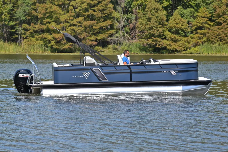Slide: The Image of 2023 Viaggio L22Q pontoon boat cruising on a lake with lush green trees in the background. - 6
