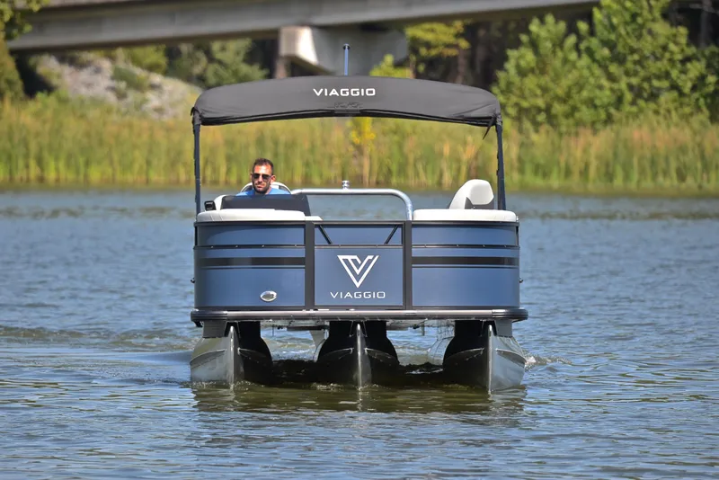 Slide: The Image of 2023 Viaggio L22Q pontoon boat cruising on a lake with a man at the helm. - 9